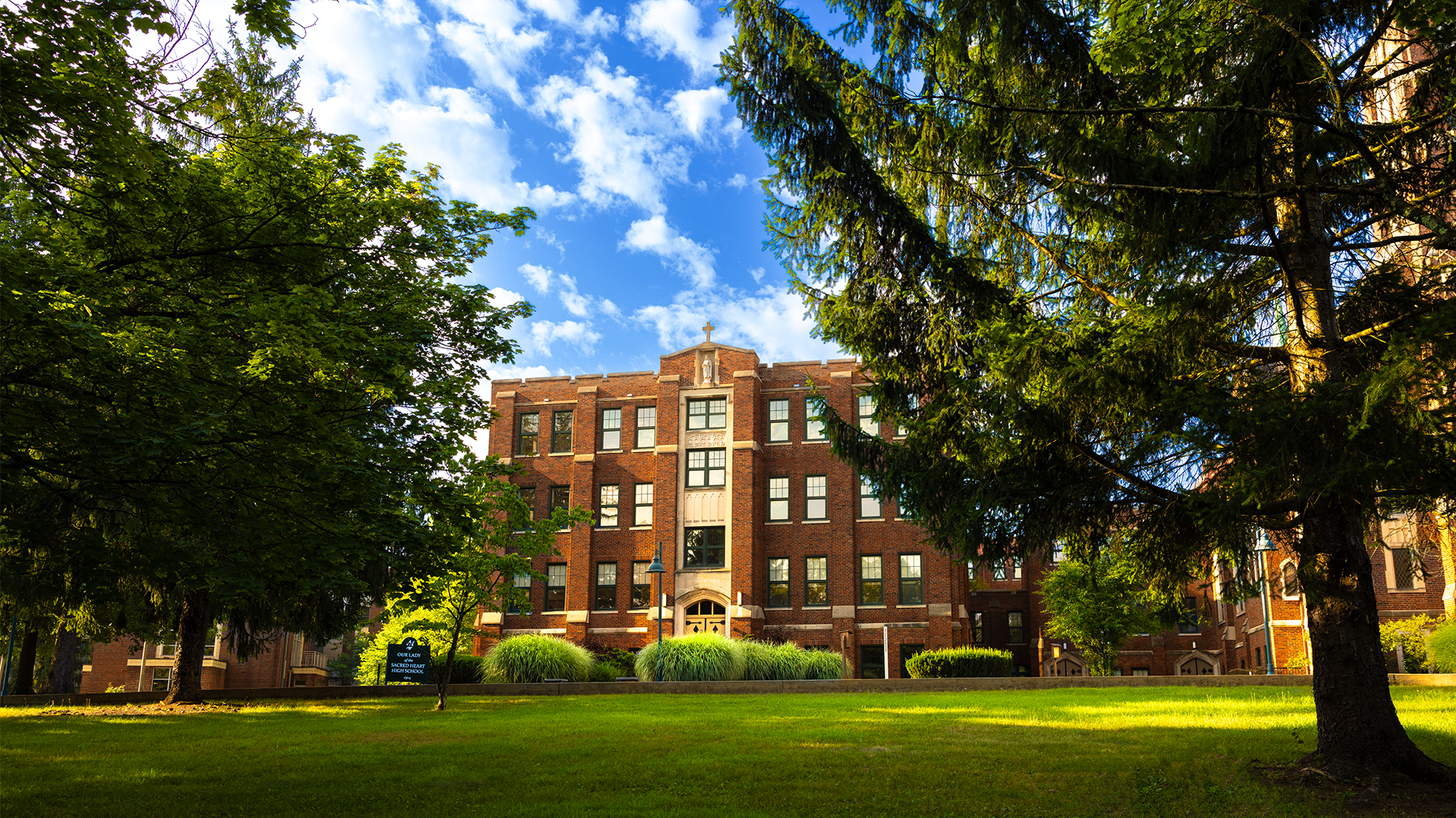 OLSH High School building with grass lawn and blue sky