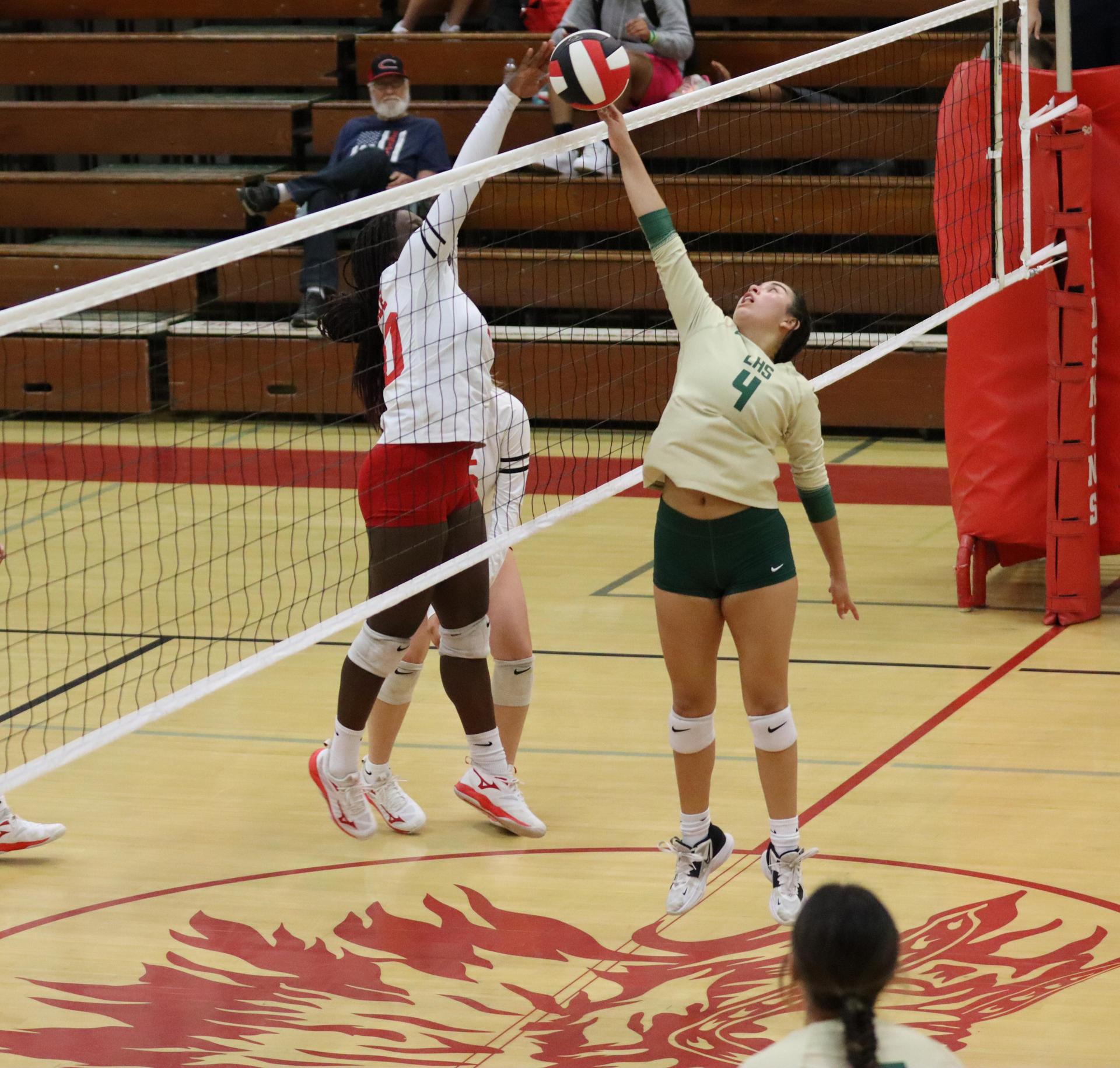 varsity volleyball players in action against liberty