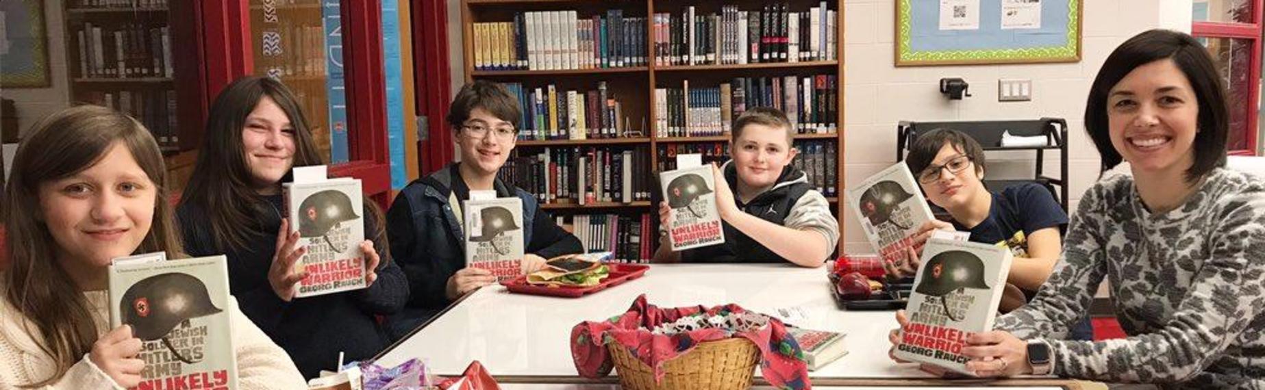 Media specialist and students show off books they are reading