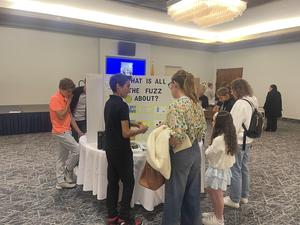 7th grade student presents at the science fair to a parent and student