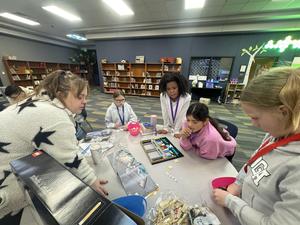 Several students gathered around working on a LEGO project