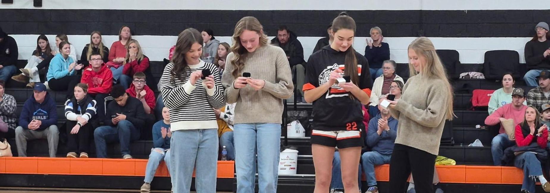 4 girls being presented with state championship rings standing in the middle of the Chilhowie High School gym floor.