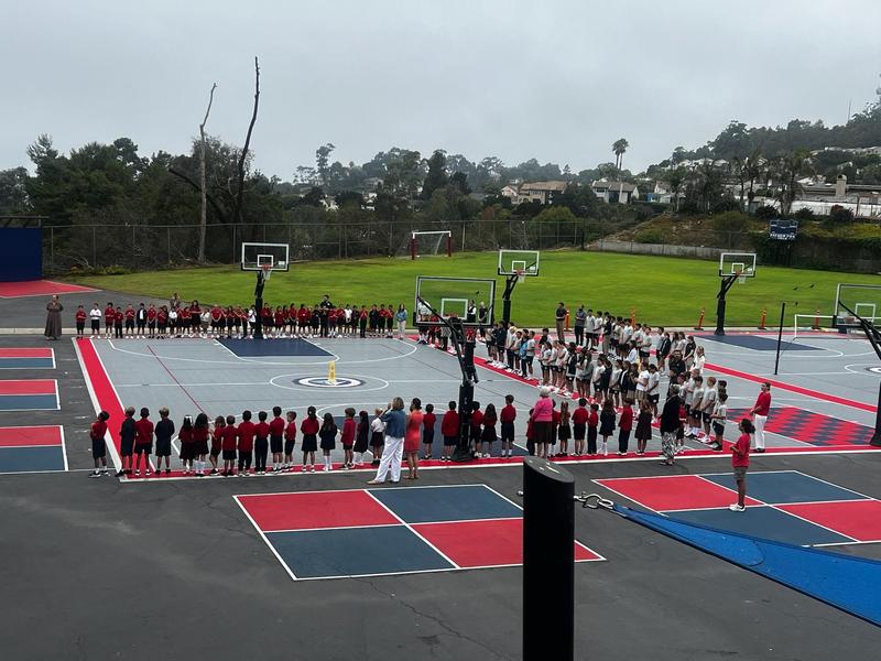 entire school gathered around sport court for morning prayer