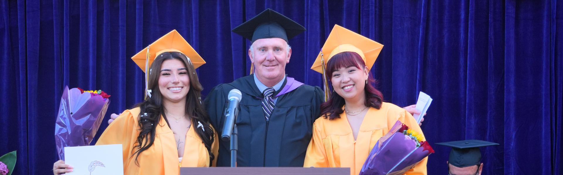 Graduating students pose with their teacher during the ceremony.