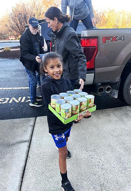 James River Day School student bringing in donated canned goods.