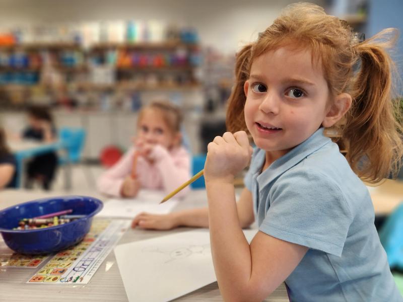 A student pauses while drawing piggy.
