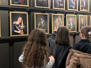 The students look at the gallery of orchestra members.