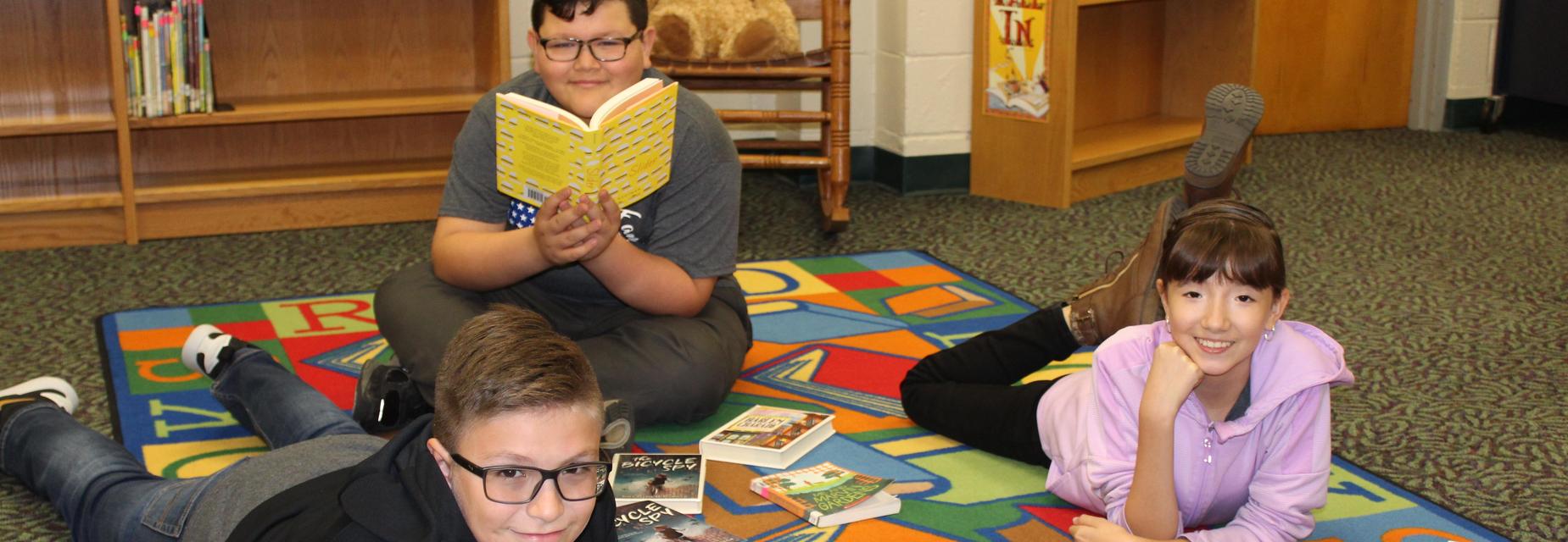 kids on carpet with books