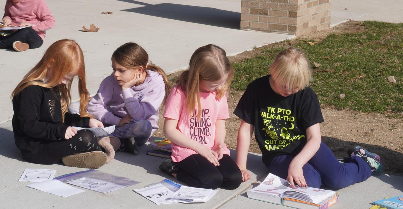 Students read outside with Lee students.