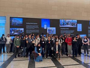 A large group of students posing together in a modern building.