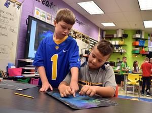 two boys tying a piece of string