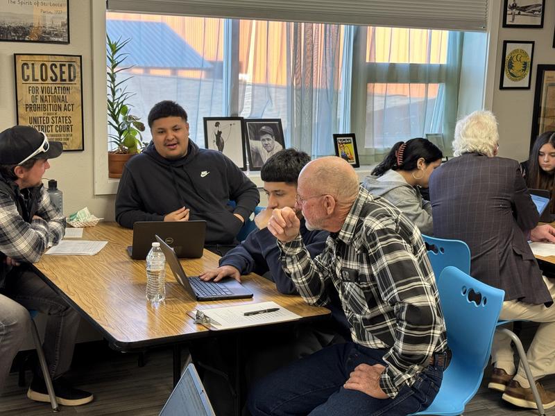 Community member working with a make student at his computer