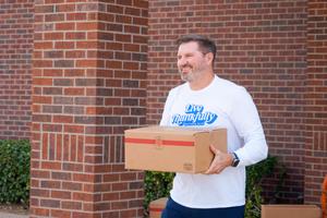 Dr. St. Clair delivering a box of food to a car