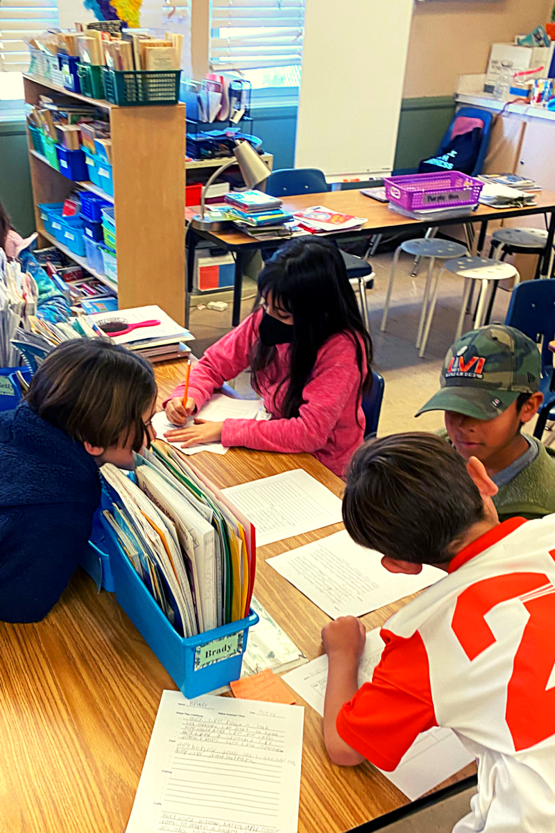 4th graders taking notes on their research about molecules and organisms