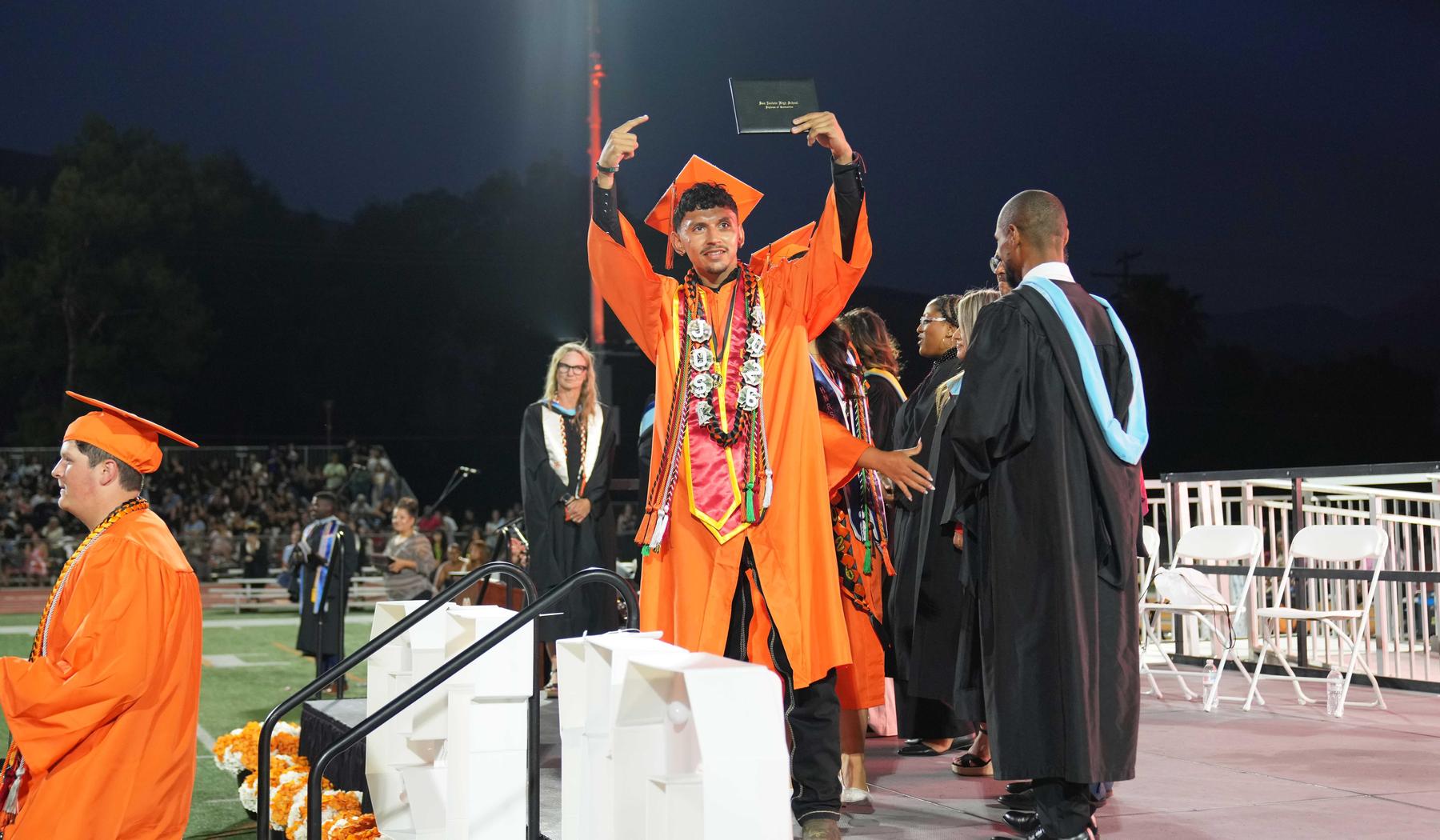 SJLA honor grad showing off diploma