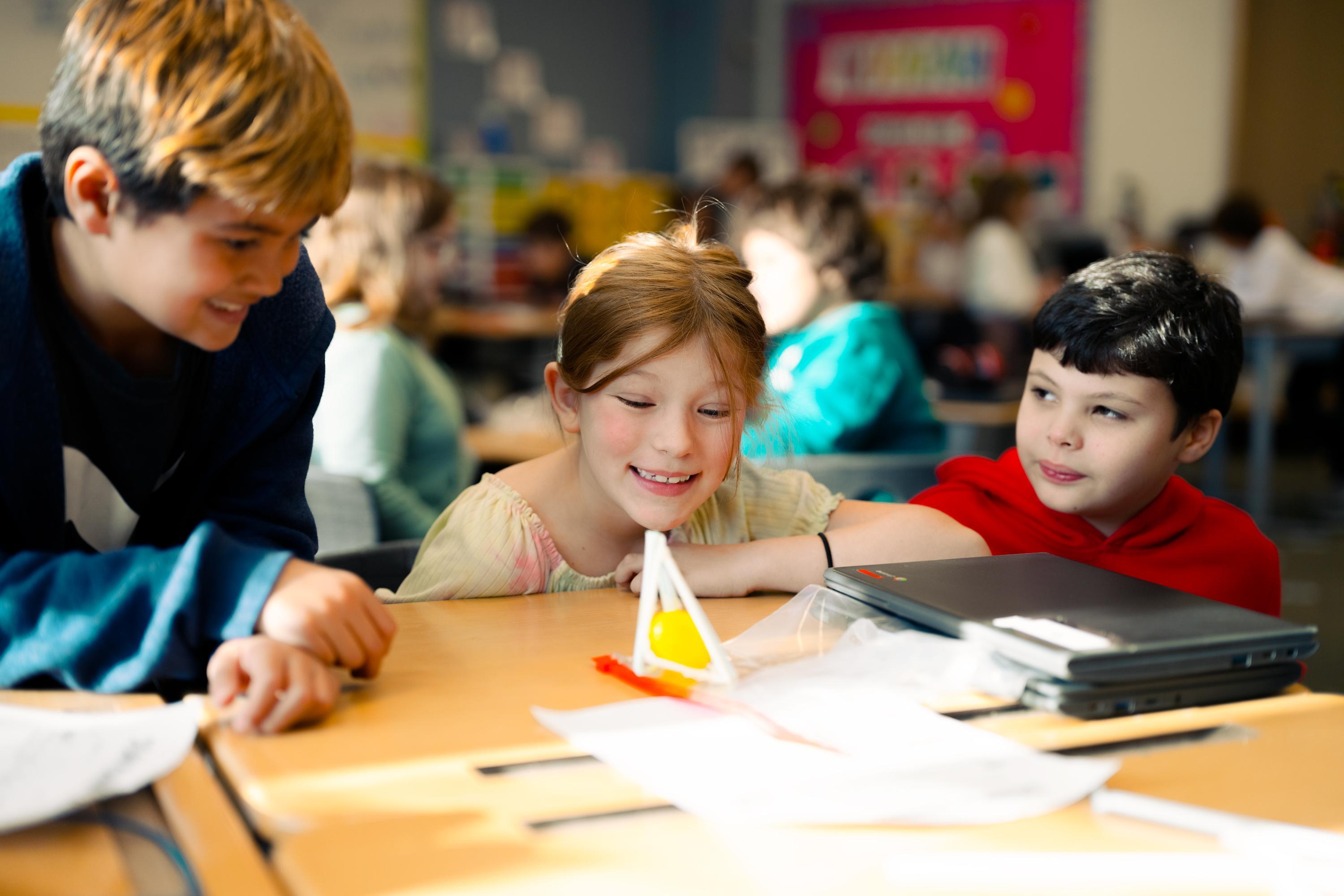 Students looking at a model of a pyramid in a science class