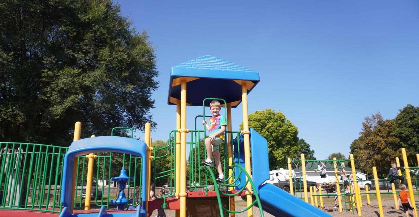 A student stands in a play structure with two slides.