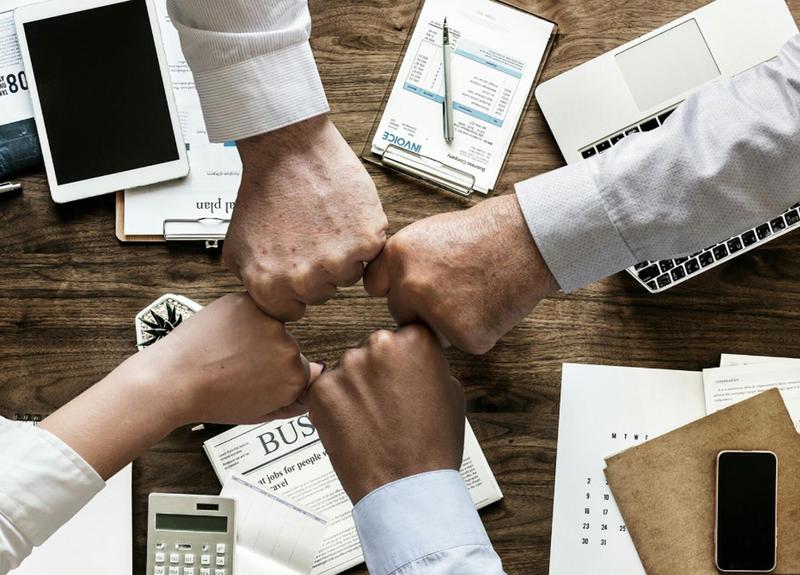 Fist bump with five people in business attire