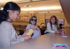three students playing cards