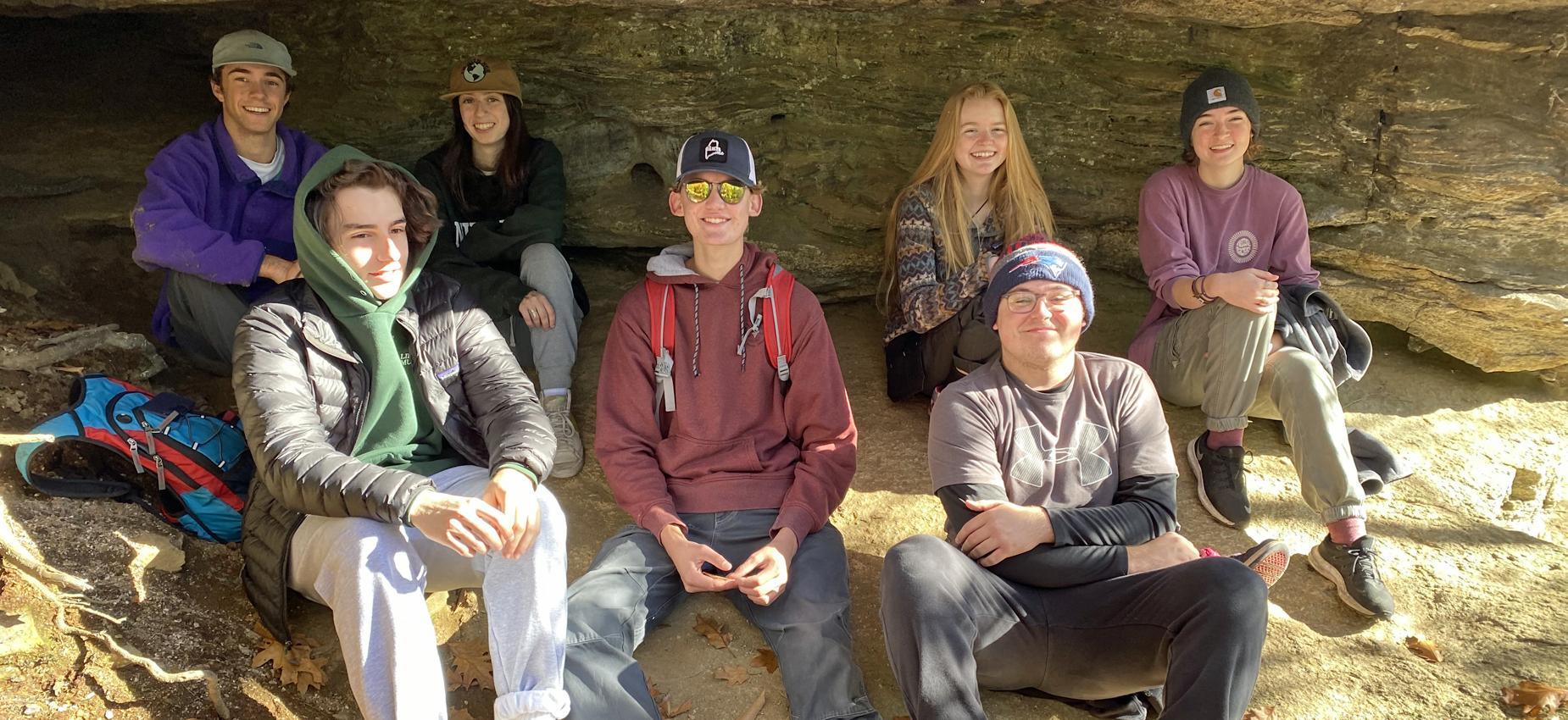 students sitting in a cave