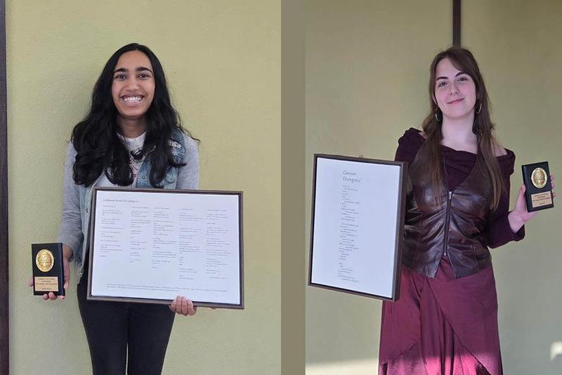Two students hold a printout of their poems as well as a gold plaque
