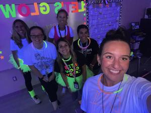 A teacher with students at the glow in the dark fun run. Students are wearing glow sticks.