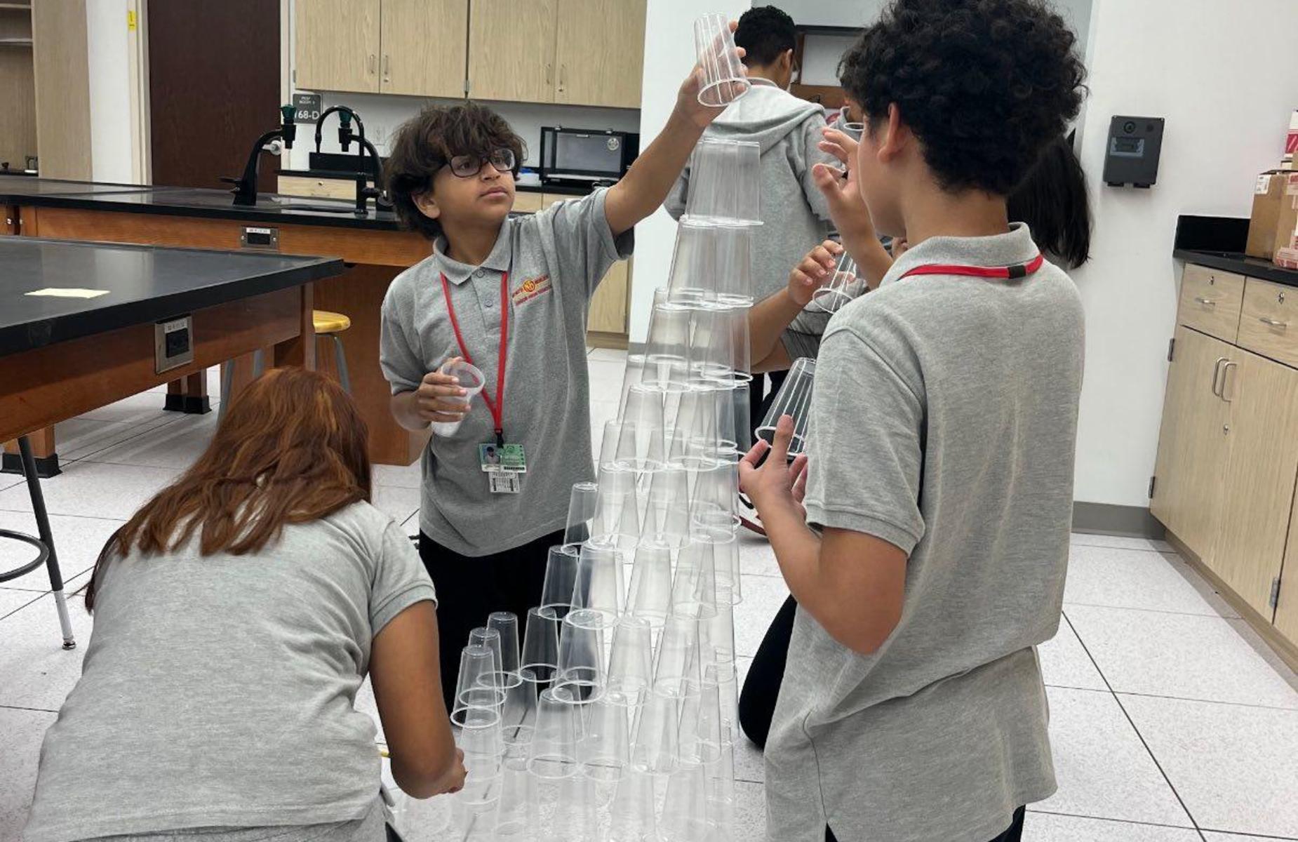 students in team building activity building with plastic cups