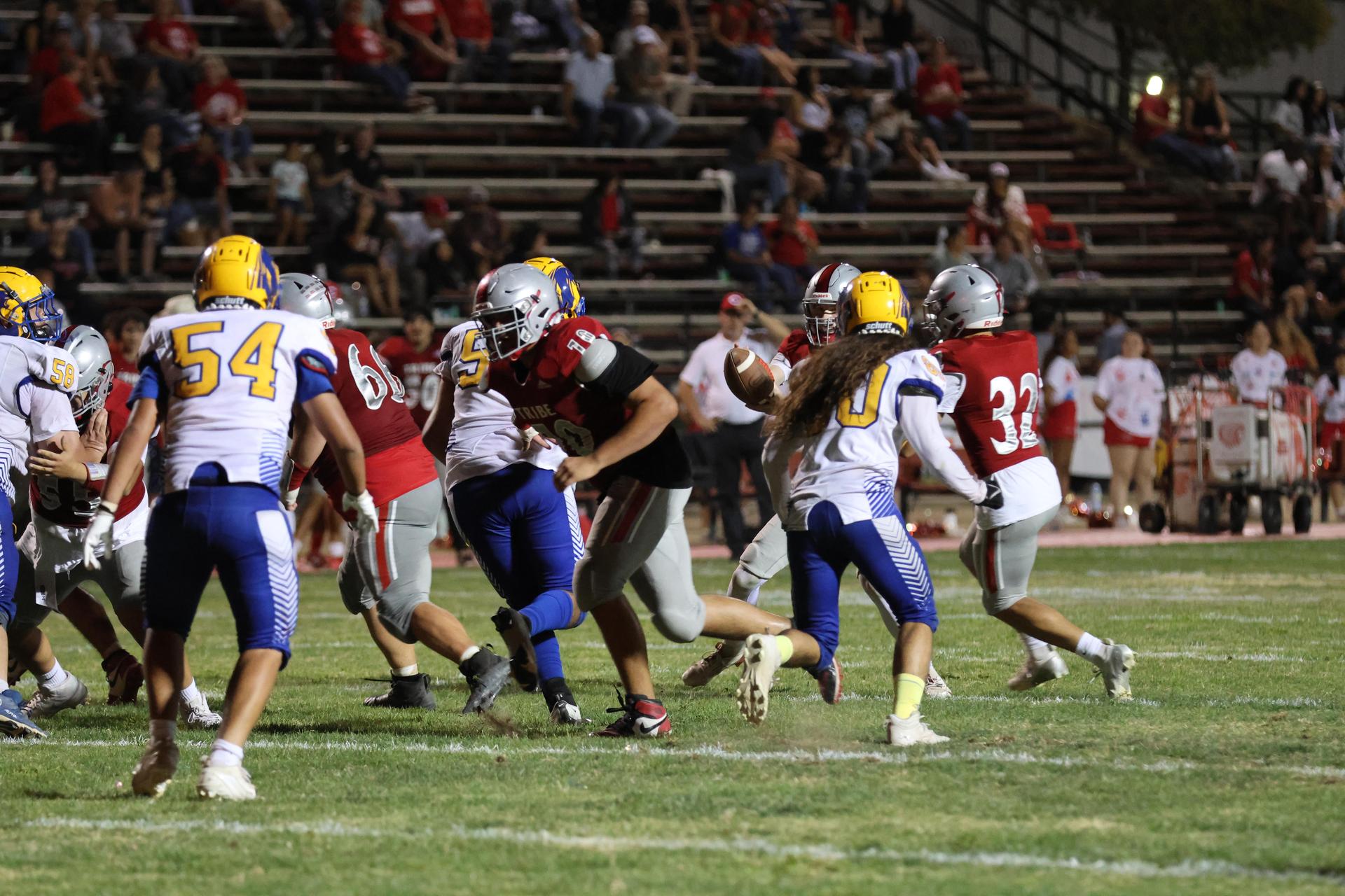 Varsity football players in action against Parlier 86