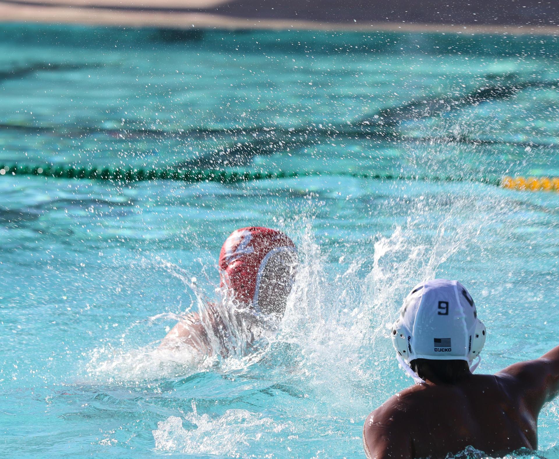 boys water polo players in action against hoover