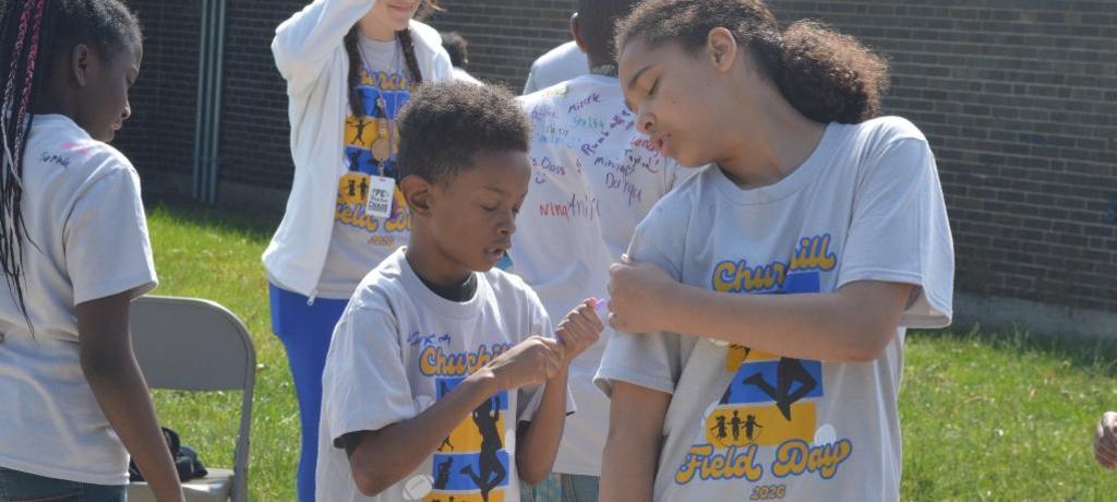 boy autographs the back of a girl's t-shirt