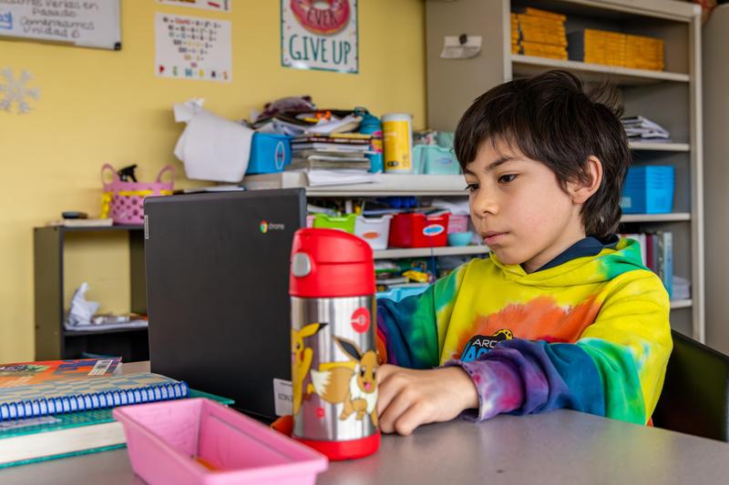 An Arco Iris student works on his school work in his classroom.