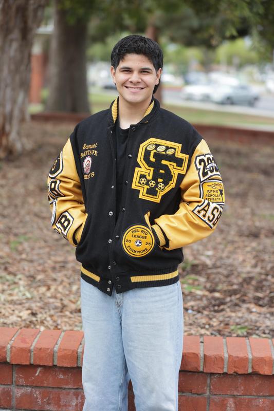 A male student from Santa Fe High School smiles at the camera while sporting his letterman jacket.