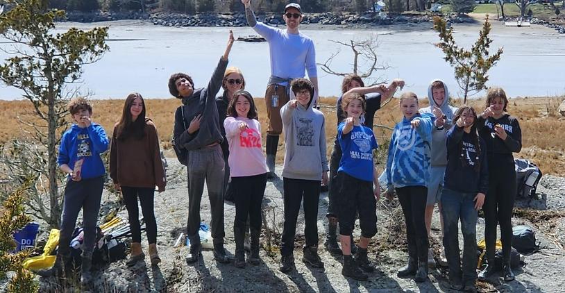 Teenagers posing outdoors with a scenic background, celebrating an achievement.