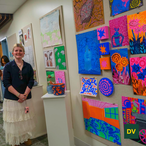Art Student Standing in front of examples of her artwork