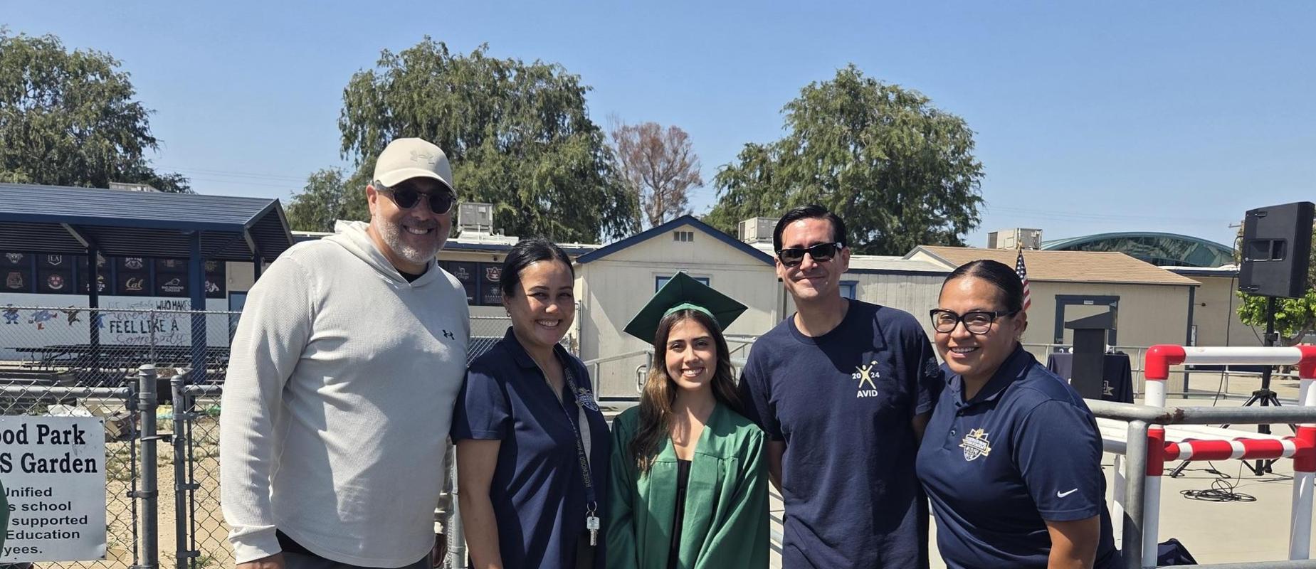 teachers and graduating former student.