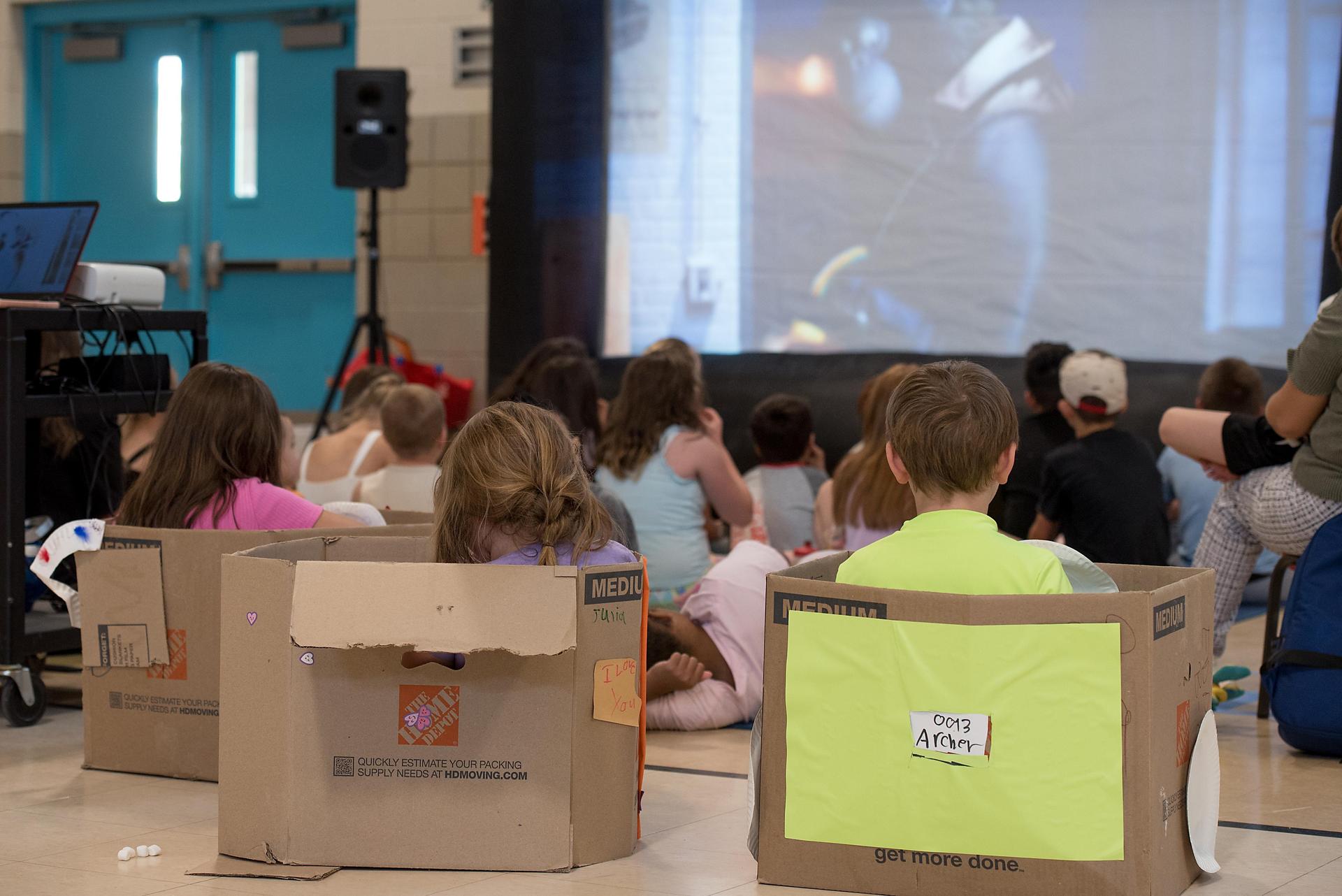 students watching a movie in cardboard cars