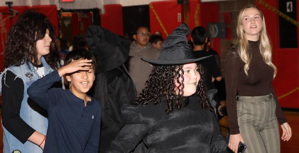 1 girl dressed as a witch, 3 other people dancing.
