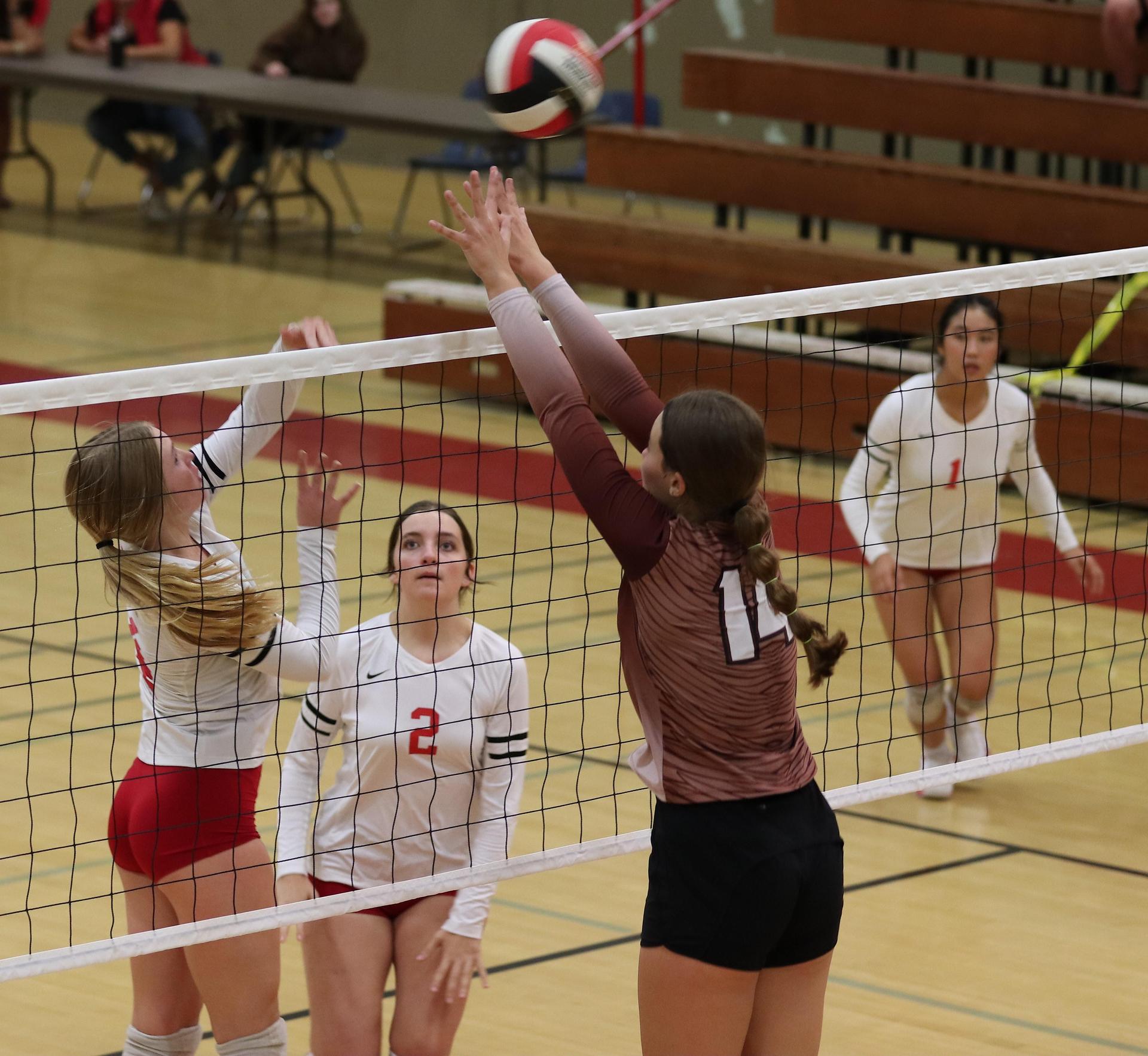 varsity volleyball players in action against Fresno Christian