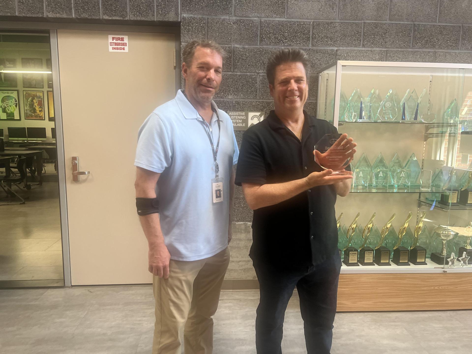teacher posing with award