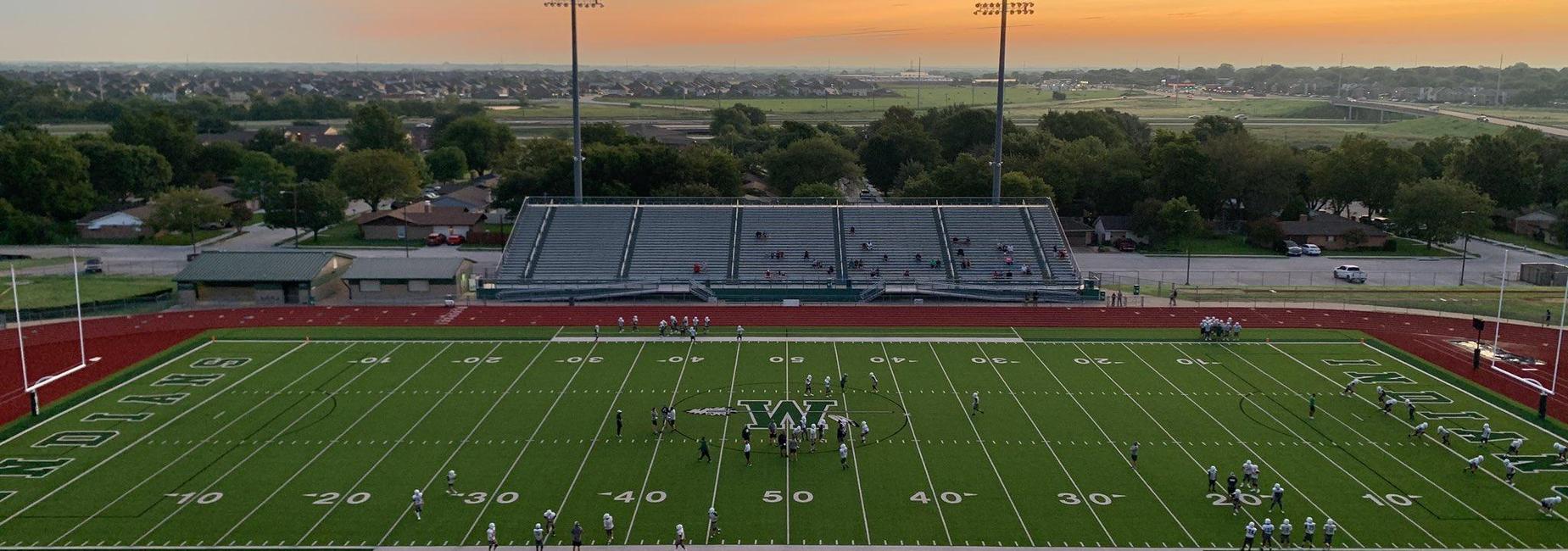 football field with sun setting in the background