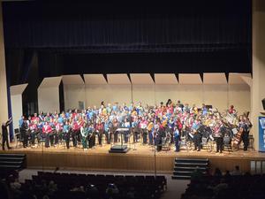 large group of high school band members on a stage
