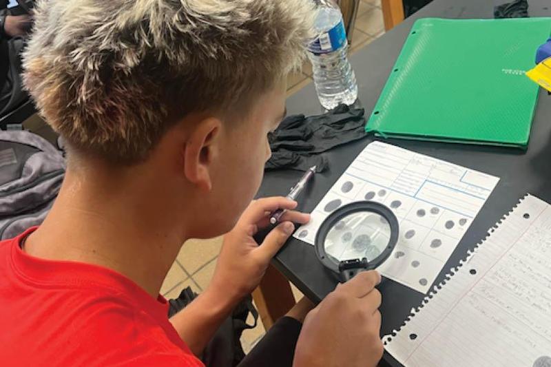 11th-grader Aiden Drotos identifies minutiae with a magnifying glass