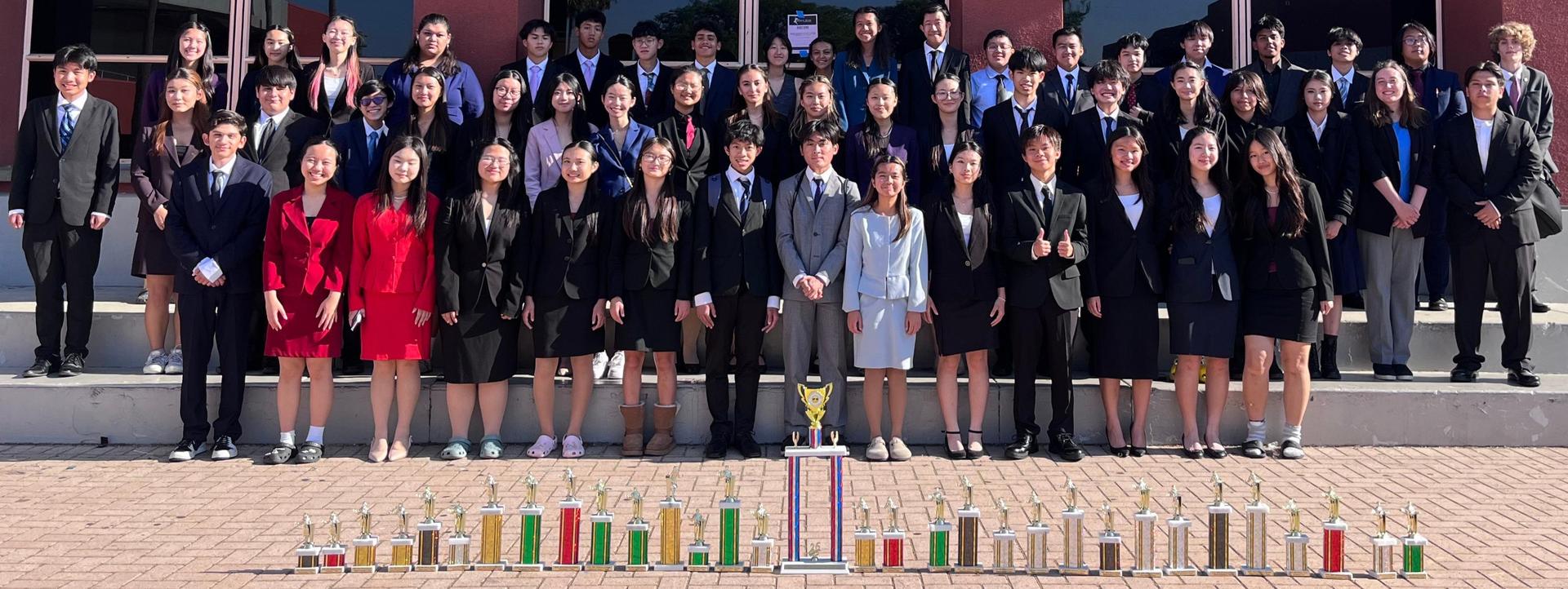 students standing in front of the Gabrielino library with their trophies