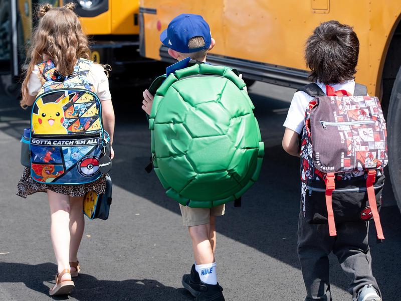 students walking toward school bus