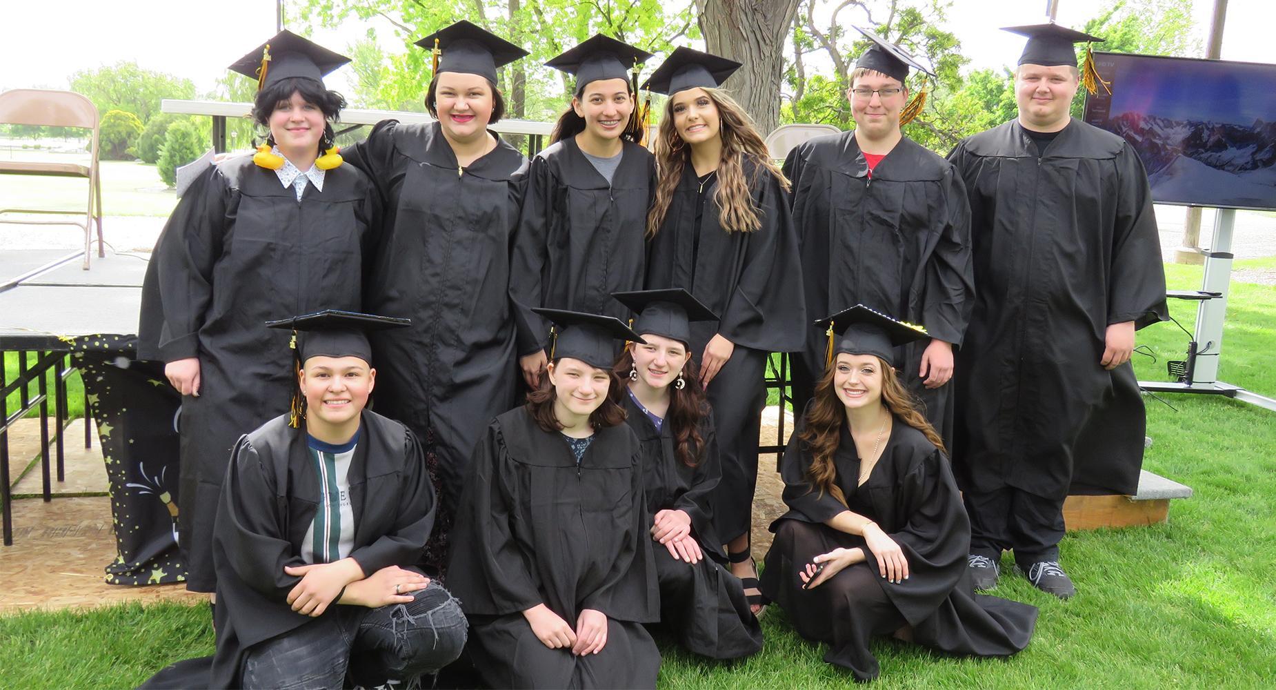 TVLA Graduates pose for a group photo wearing caps and gowns.