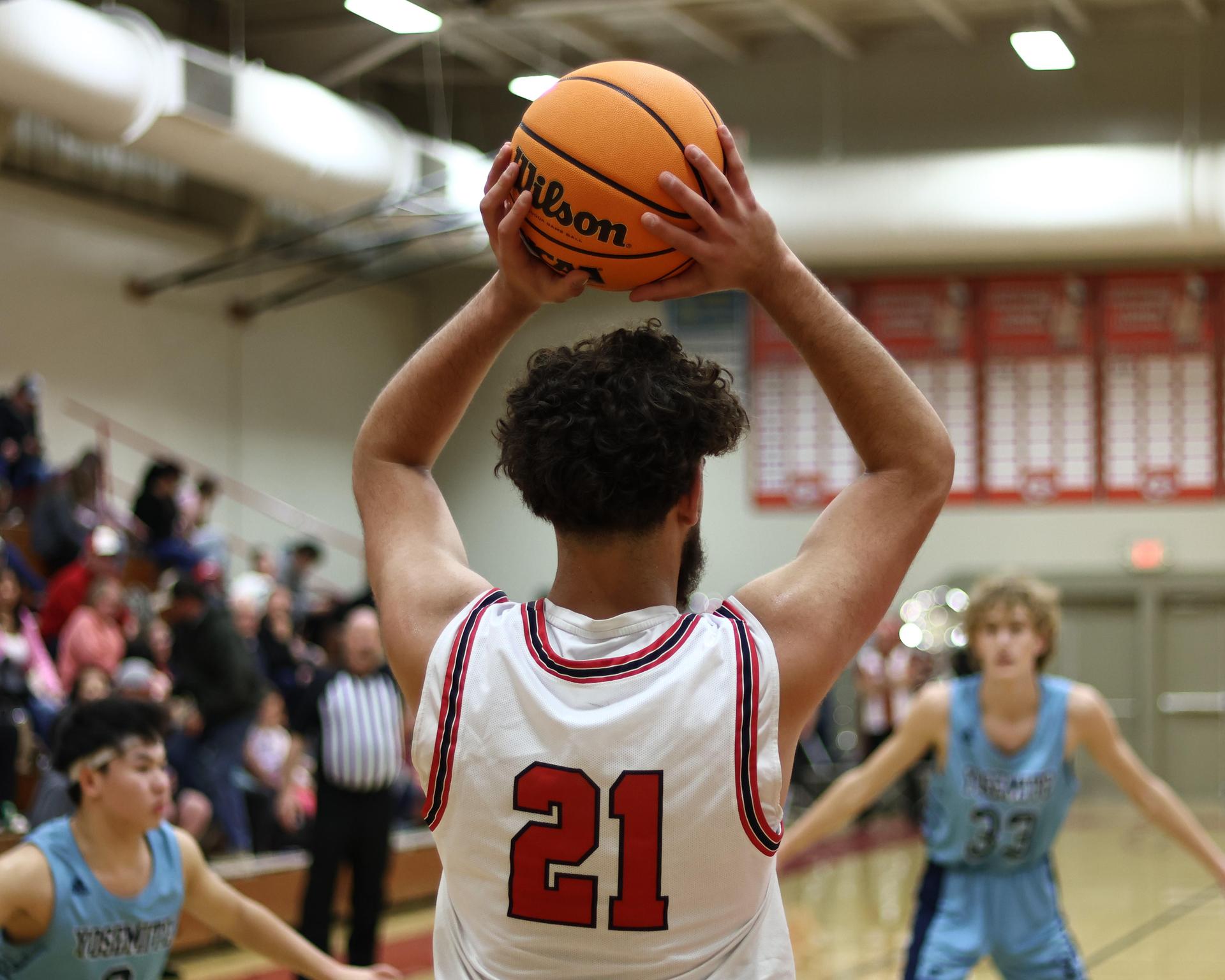 Varsity boys playing basketball against yosemite
