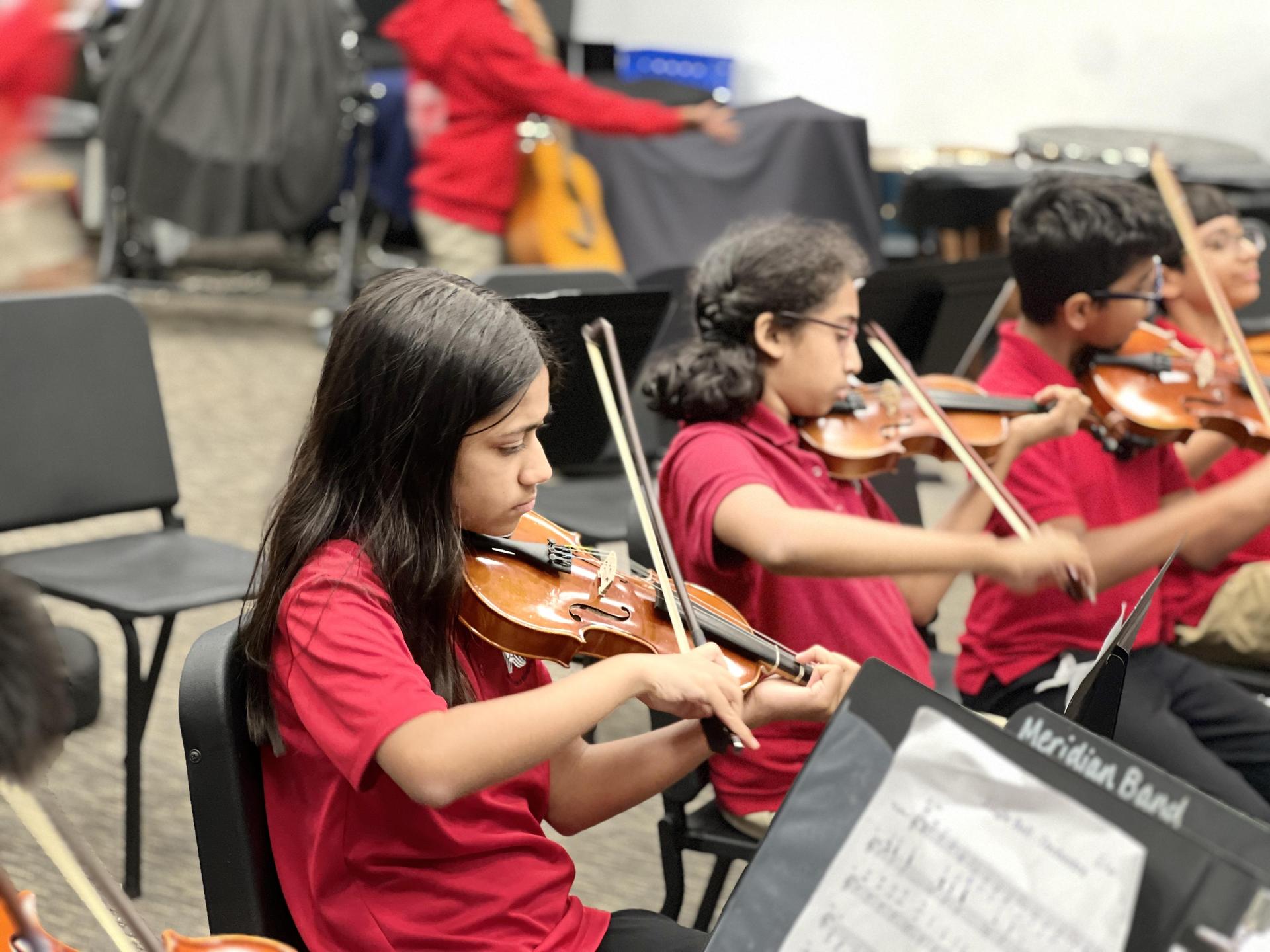 Students play stringed instruments