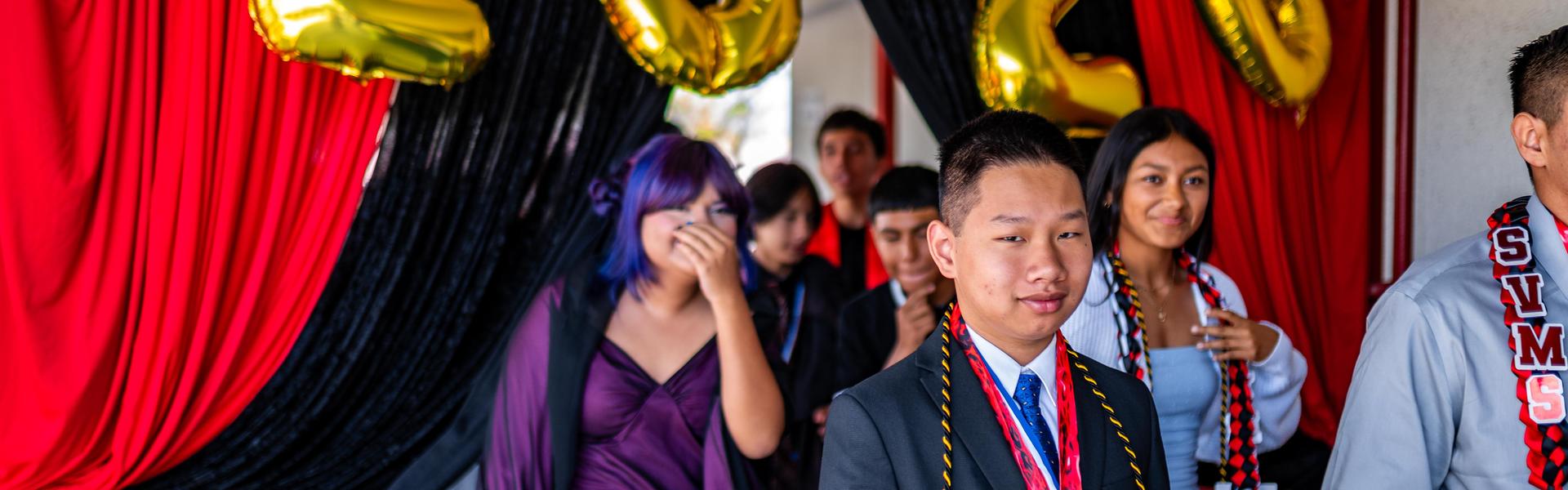 Students walking through a decorated entrance for a celebration event.