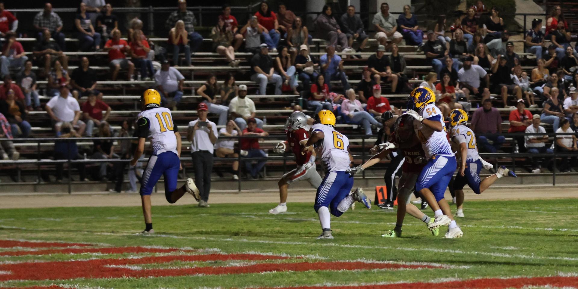 Varsity football players in action against Parlier 34