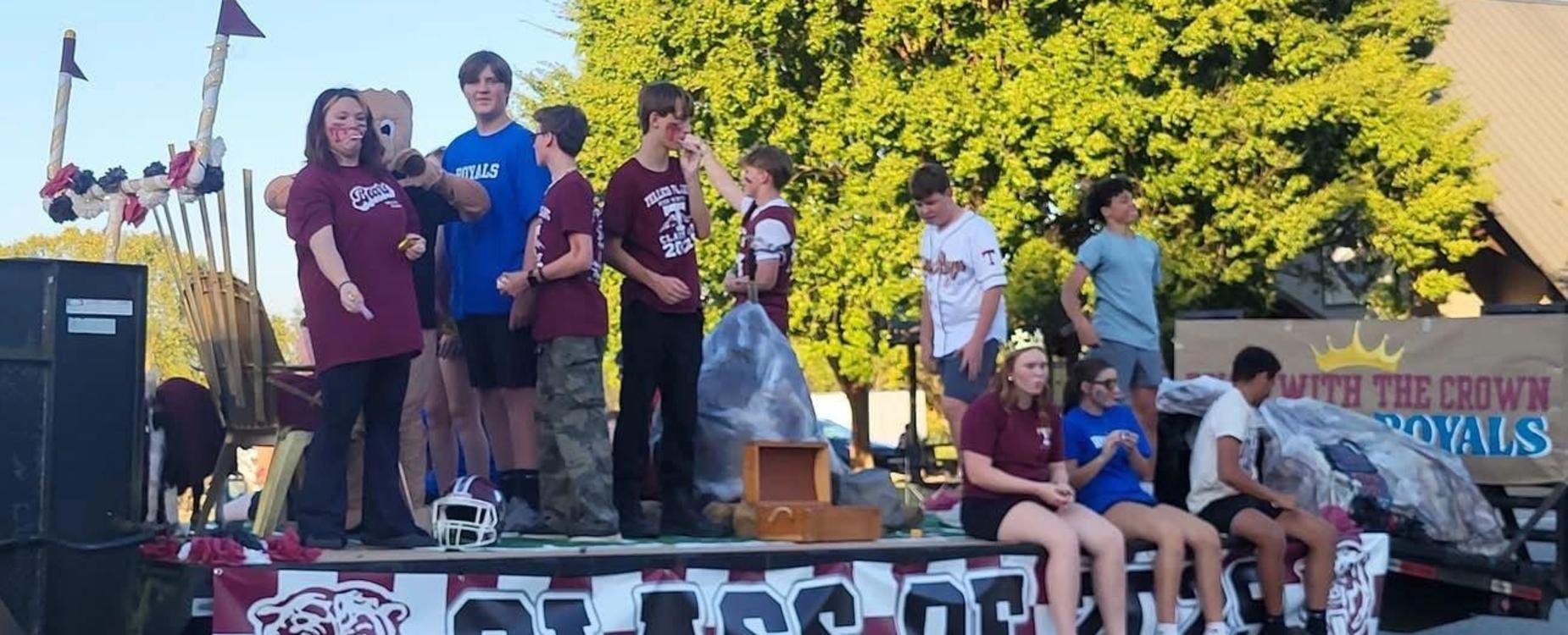 Students celebrating on a float during a parade, showcasing school spirit and activities.